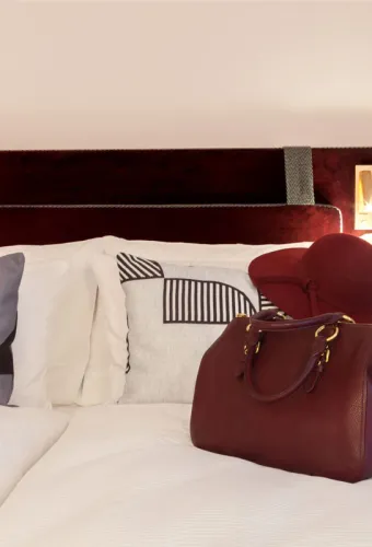 Elegantes Zimmer mit rotem Kopfteil und Dekoration im Hotel Elephant Weimar für einen Sommerurlaub.
