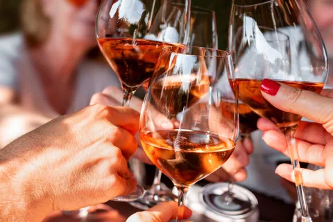 Vier Weingläser, die beim Weinfest im Weimar miteinander anstoßen. © Adobe Stock