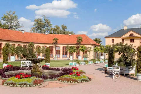 Orangerie im Schlosspark Belvedere in Weimar mit Brunnen, Blumenbeeten und barocker Gartenanlage an einem sonnigen Tag.