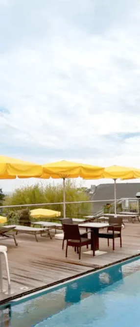 Poolterrasse mit Sonnenschirmen und Blick auf die Seebrücke Heringsdorf für den perfekten Sommerurlaub im Hotel Kaiserhof.