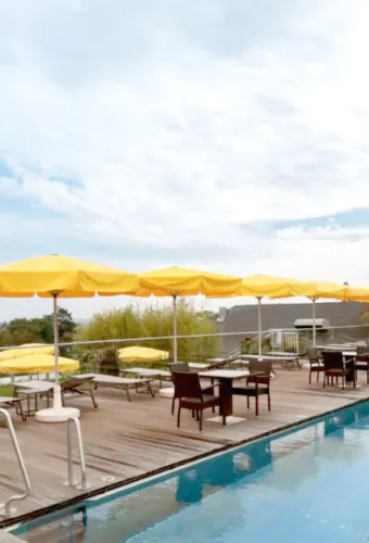 Poolterrasse mit Sonnenschirmen und Blick auf die Seebrücke Heringsdorf für den perfekten Sommerurlaub im Hotel Kaiserhof.