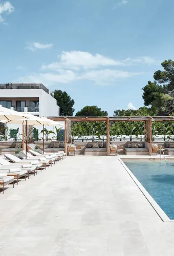 Einladende Poolanlage mit Sonnenliegen und Schirmen im Barefoot Hotel Mallorca, ideal für deinen Urlaub.