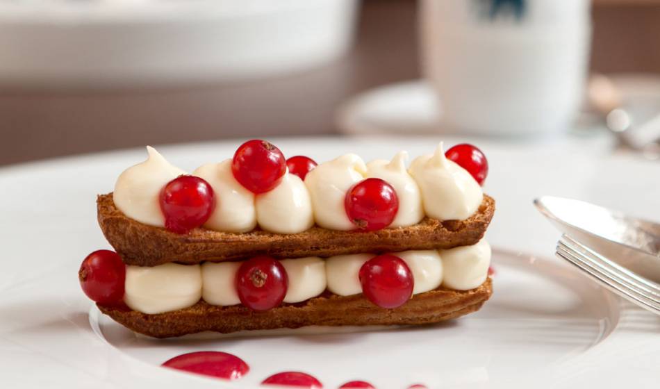 Feines Dessert mit Sahne und roten Beeren, liebevoll angerichtet im Hotel Elephant Weimar.