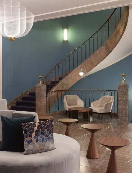 Moderne Lobby mit geschwungener Treppe, stilvollen Sesseln und elegantem Dekor im Elephant Hotel Weimar.