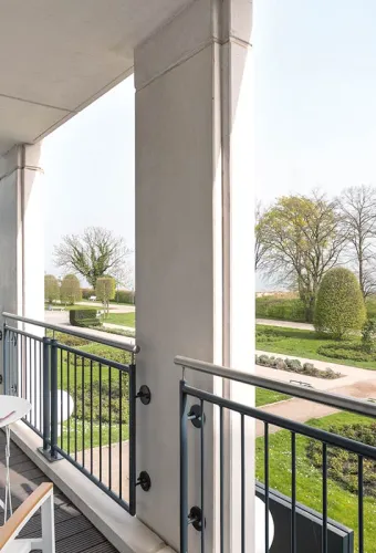 Balkon im Hotel Kaiserhof Heringsdorf mit Sitzmöbeln und Blick auf Park und Strand