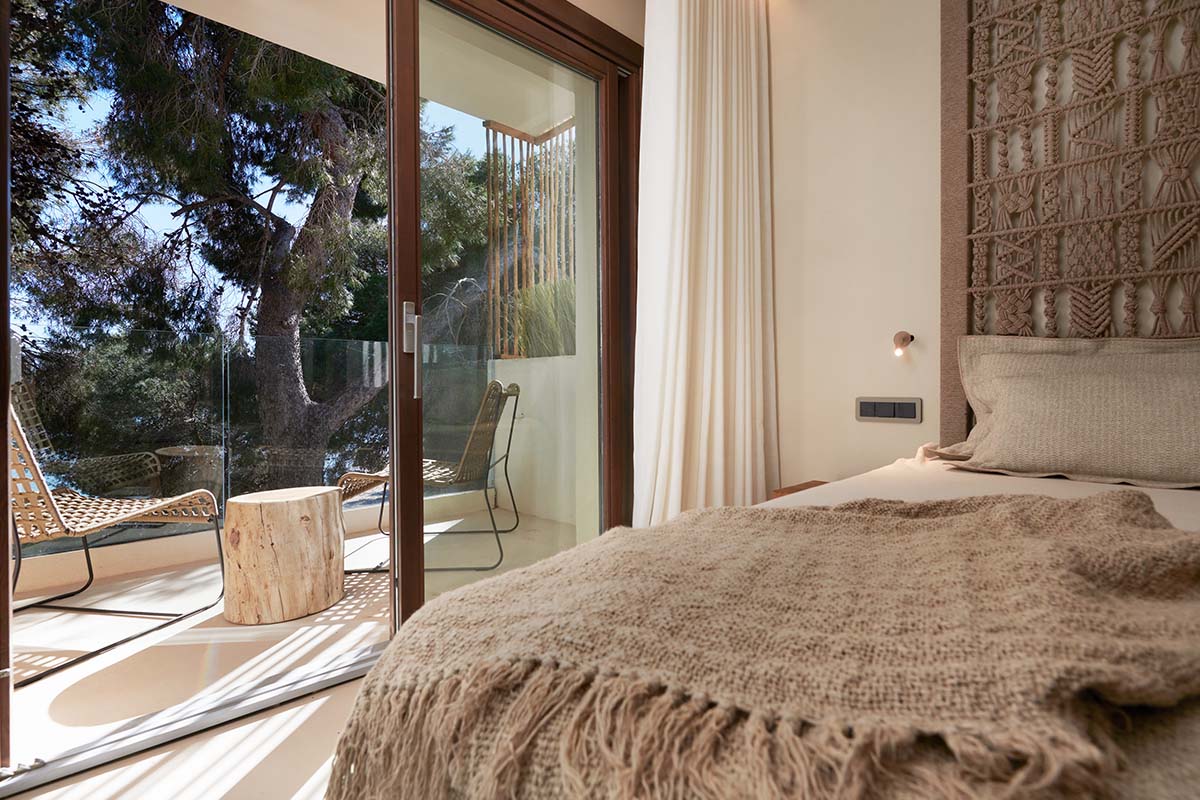 Habitación doble Mar en el Hotel Pies Descalzos de Mallorca con cama de estilo, acceso a la terraza y vistas a la naturaleza.