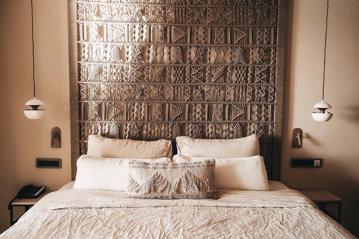 Zona de descanso en la habitación doble Mar del Hotel Barefoot Mallorca con cama grande, cabecero decorativo y elegante iluminación.