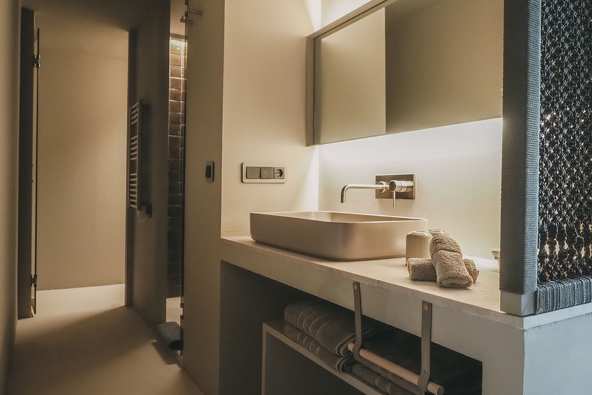 Modernes Badezimmer im Zimmer Pino des Barefoot Hotel Mallorca mit Design-Waschbecken und stimmungsvollem Licht.