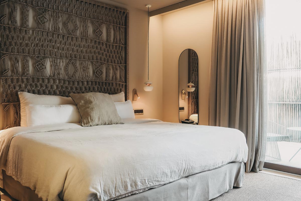 Einladender Schlafplatz im Zimmer Pino des Barefoot Hotel Mallorca, mit weichen Kissen und stilvollem Ambiente.