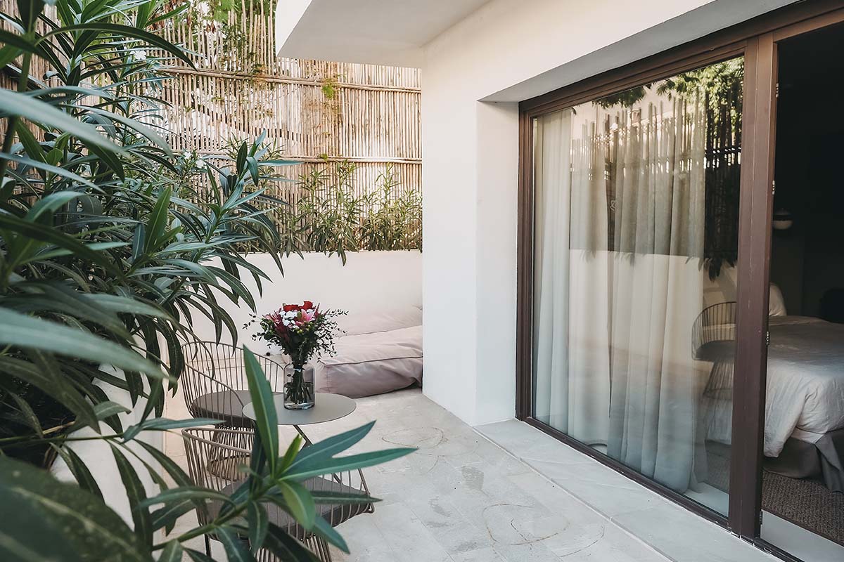 Private Terrasse im Zimmer Pueblo des Barefoot Hotel Mallorca mit Dekoration, Blumen und viel Grün.