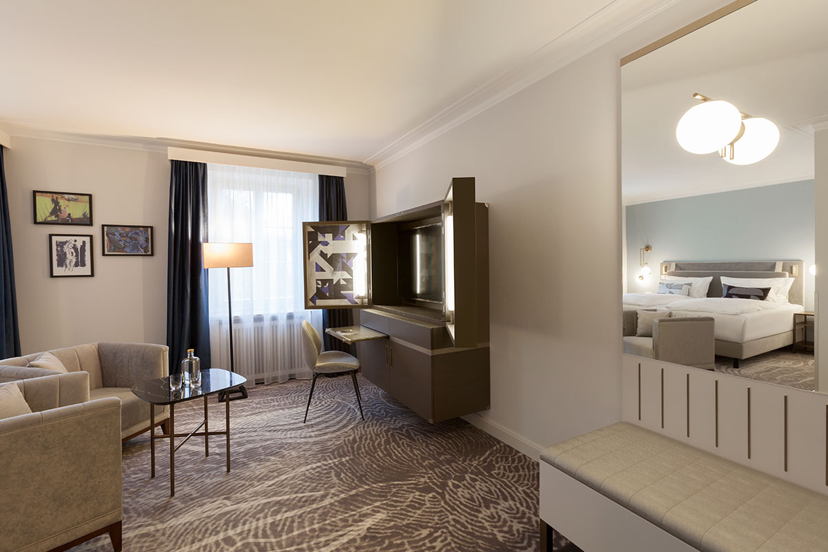 Sitzbereich im Grand Deluxe Zimmer des Hotel Elephant Weimar mit Sesseln, Couchtisch und eleganter Dekoration.