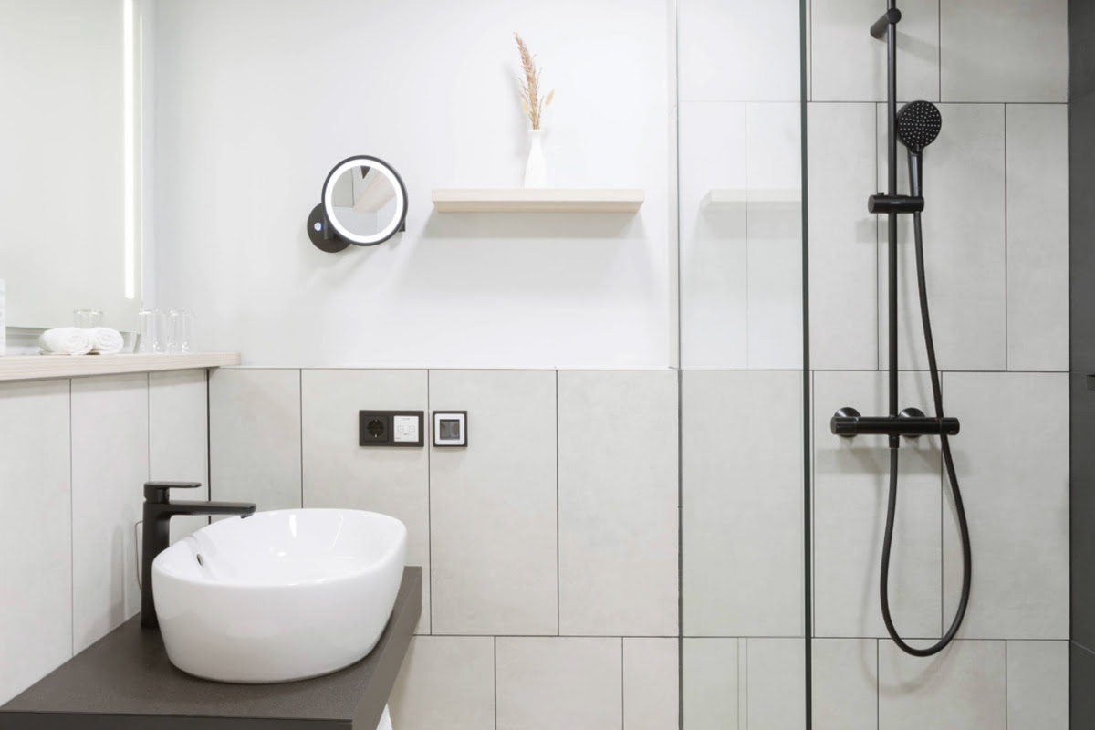 Modern eingerichtetes Bad mit großer Dusche und schlichtem Design im Deluxe-Doppelzimmer im Hotel Kaiserhof Heringsdorf.