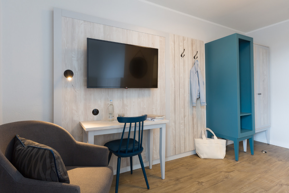 Single room with modern seating area in Scandinavian style at Koopmanns Hotel &amp; Lädchen.