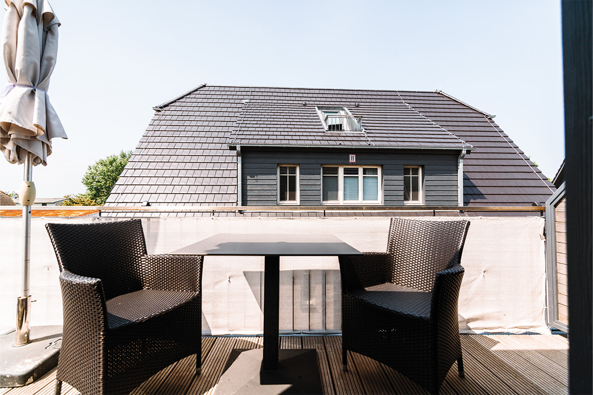 Balkon mit Tisch und zwei Stühlen in der Ferienwohnung Seepferd im Dünenpark, perfekt für ein Frühstück an der frischen Luft
