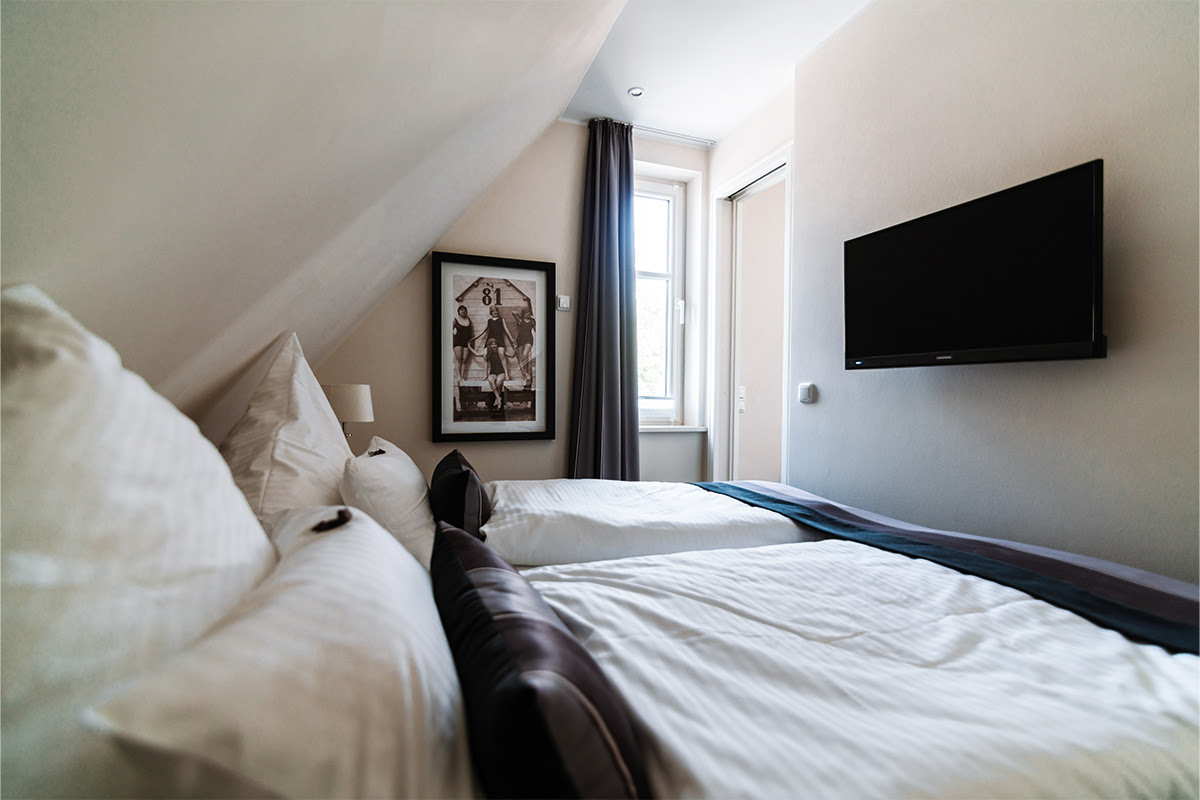 Doppelbett im modernen Schlafzimmer in der Ferienwohnung Stranddüne im Hotel Künstlerquartier Seezeichen.
