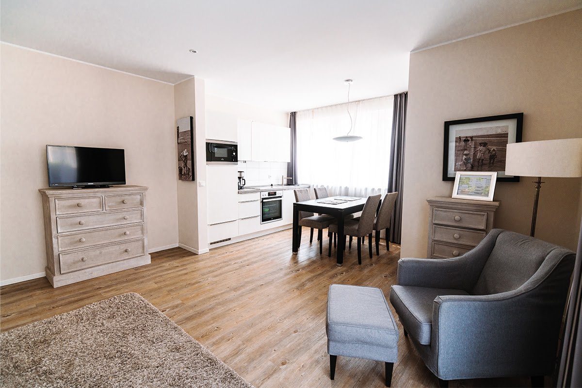 Moderne Ferienwohnung Strandmuschel mit Essbereich und offener Küche im Hotel Künstlerquartier Seezeichen.