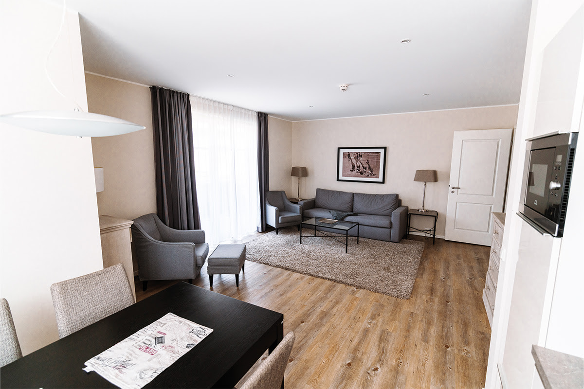 Heller Ess- und Wohnraum mit bequemen Sitzmöbeln in der Ferienwohnung Strandmuschel im Hotel Künstlerquartier Seezeichen.