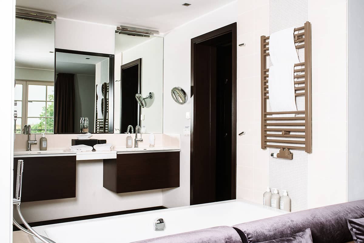 Modernes Badezimmer mit Doppelwaschbecken und großer Badewanne der Deluxe Suite im Hotel Künstlerquartier Seezeichen.