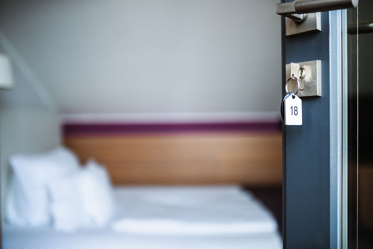 Nahaufnahme einer geöffneten Tür mit Schlüssel zum Einzelzimmer des Hotel Künstlerquartier Seezeichen in Ahrenshoop.