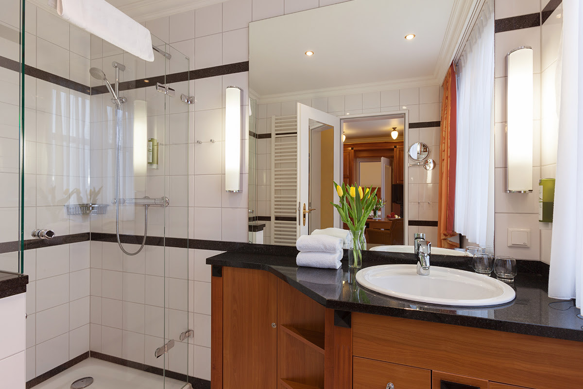 Komfortables Bad mit Regendusche, edlem Waschtisch, hochwertigen Armaturen im Doppelzimmer des Vju Hotels.