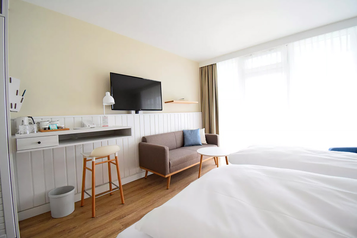 Schreibtisch mit Barhocker und stilvoller Beleuchtung, ideal für kreative Pausen und konzentriertes Arbeiten im Wyn. Strandhotel.