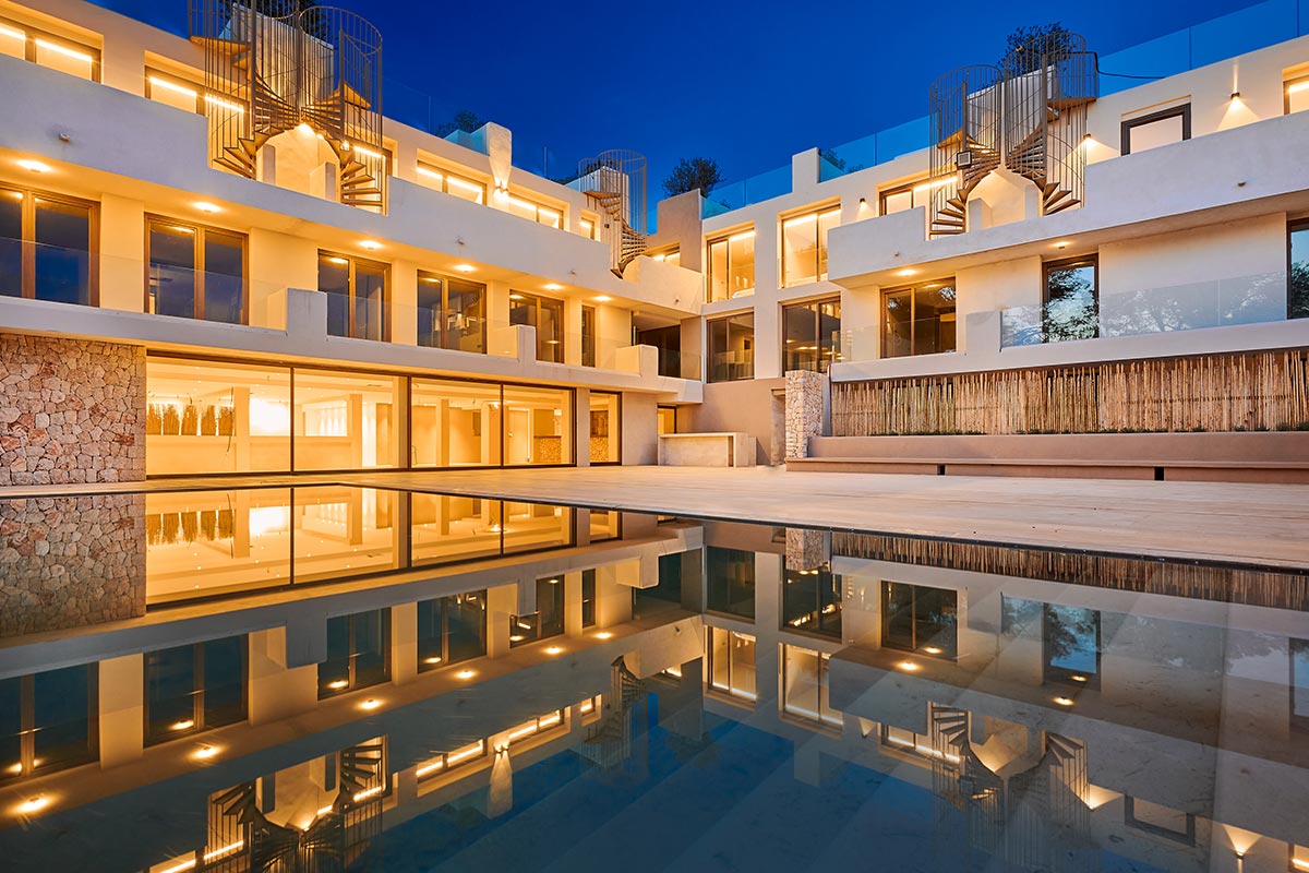 Modern pool area with reflecting pool and atmospheric lighting at night in the Barefoot Hotel Mallorca.
